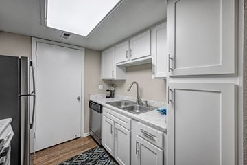 Aurora apartment for rent - A kitchen with white cabinets and a black refrigerator.