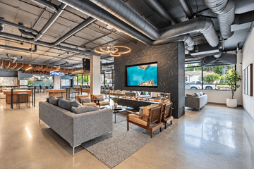 Shoreline apartment for rent - A modern living room with a grey sofa and a large TV mounted on the wall.