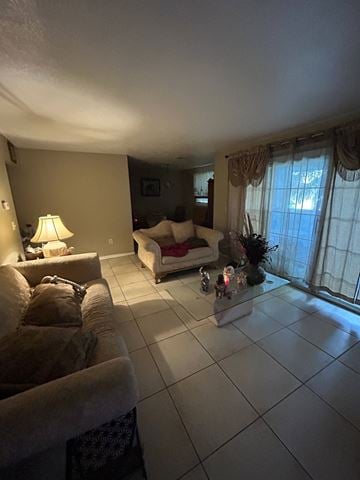 Orlando apartment for rent - A living room with a couch, a chair, a lamp, and a table with a vase of flowers.