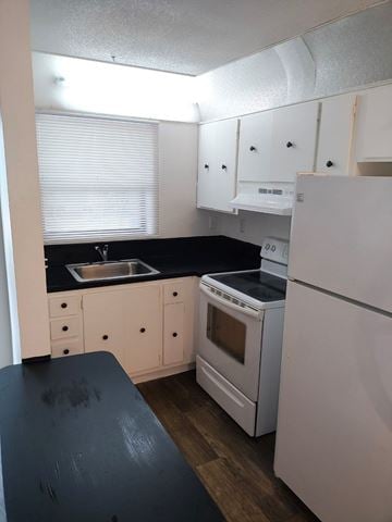 Ft. Lauderdale apartment for rent - A kitchen with white appliances and black countertops.
