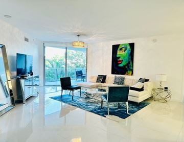 North Miami Beach apartment for rent - A modern living room with a black chair and a painting on the wall.