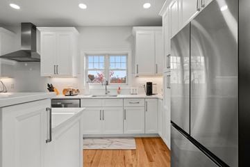Guilford apartment for rent - A modern kitchen with white cabinets and a large stainless steel refrigerator.