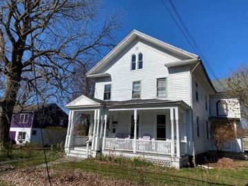 Clinton apartment for rent - A white house with a porch and a tree in front.