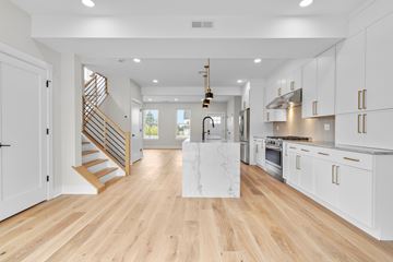 North Haven apartment for rent - A modern kitchen with white cabinets and a wooden floor.
