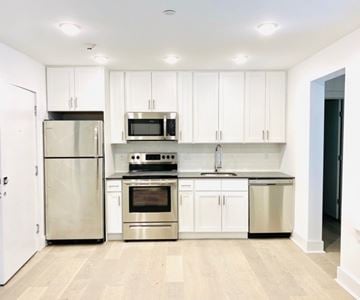 Chelsea apartment for rent - A kitchen with white cabinets and stainless steel appliances.