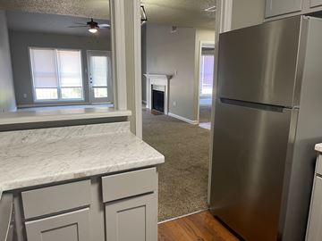 Little Rock apartment for rent - A kitchen with a marble counter top and a stainless steel refrigerator.