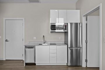 Providence apartment for rent - A modern kitchen with white cabinets and stainless steel appliances.