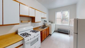 Chicago apartment for rent - A white stove and oven in a kitchen with wooden cabinets.