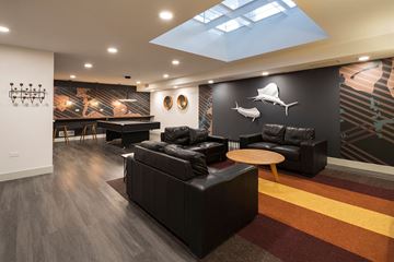 Chicago apartment for rent - A modern living room with a black couch and a skylight.