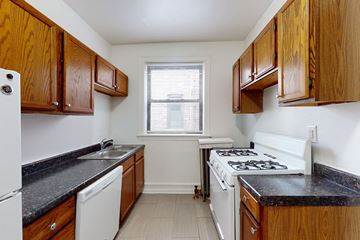 Chicago apartment for rent - A kitchen with wooden cabinets and black countertops.
