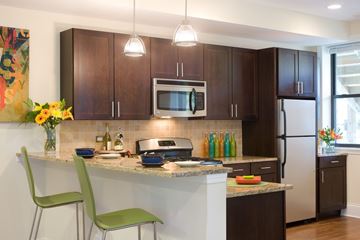 Chicago apartment for rent - A kitchen with a white countertop and green chairs.