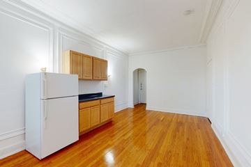 Chicago apartment for rent - A kitchen with a white refrigerator and wooden cabinets.