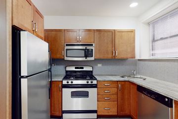 Chicago apartment for rent - A kitchen with a refrigerator, microwave, oven, and sink.