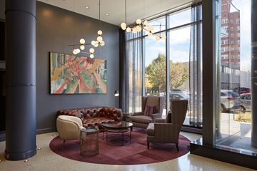 Chicago apartment for rent - A modern living room with a large window and a painting on the wall.
