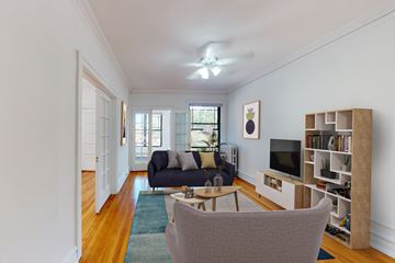 Chicago apartment for rent - A living room with a grey couch and a television.