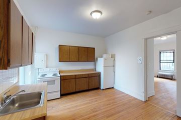Chicago apartment for rent - A kitchen with wooden cabinets and a white fridge.