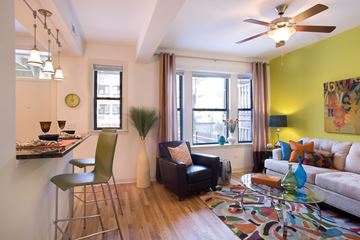 Chicago apartment for rent - A living room with a black leather chair and a white couch.