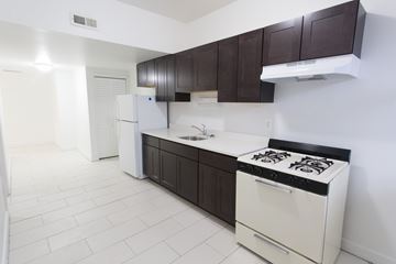 Chicago apartment for rent - A white stove is in a kitchen with white tile flooring.