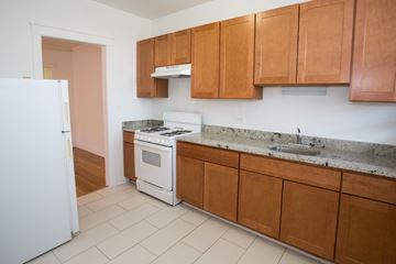 Chicago apartment for rent - A kitchen with white appliances and wooden cabinets.