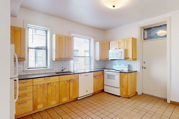 Chicago apartment for rent - A kitchen with wooden cabinets and white appliances.