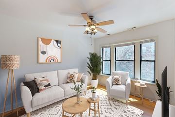 Chicago apartment for rent - A living room with a white couch, a coffee table, and a ceiling fan.