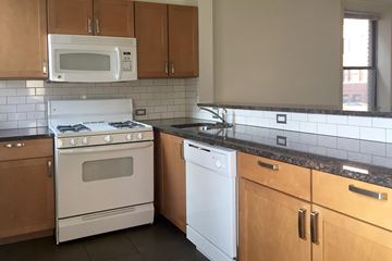 Chicago apartment for rent - A kitchen with a white stove top oven and a white dishwasher.