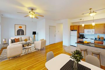 Chicago apartment for rent - A living room with a white couch and a dining table with chairs.