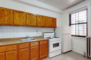 Chicago apartment for rent - A kitchen with wooden cabinets and white appliances.