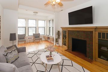 Chicago apartment for rent - A living room with a fireplace and a television mounted above it.
