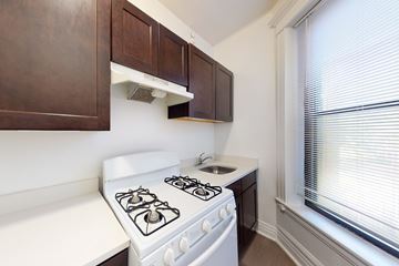 Chicago apartment for rent - A white stove in a kitchen with brown cabinets.