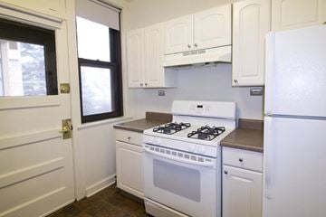 Chicago apartment for rent - A white kitchen with a stove and a refrigerator.
