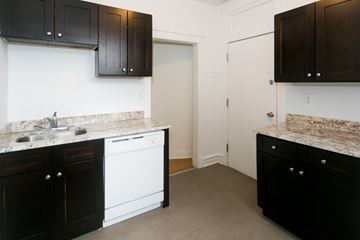 Chicago apartment for rent - A kitchen with black cabinets and a white dishwasher.