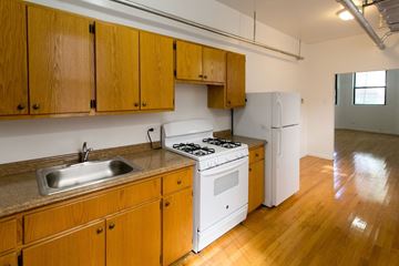 Chicago apartment for rent - A kitchen with wooden cabinets and a white stove top oven.