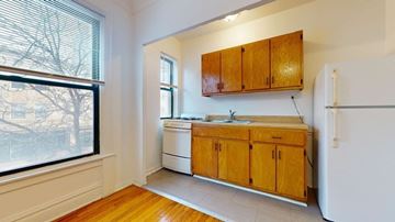 Chicago apartment for rent - A kitchen with wooden cabinets and a white refrigerator.