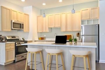 Chicago apartment for rent - A kitchen with a white counter and wooden bar stools.