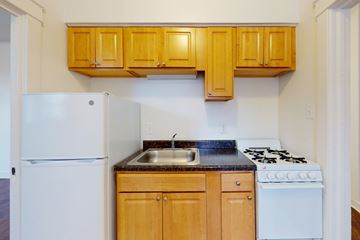 Chicago apartment for rent - A kitchen with wooden cabinets and a white refrigerator.