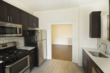 Chicago apartment for rent - A kitchen with black cabinets and a stove top oven.