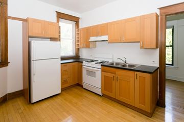 Chicago apartment for rent - A kitchen with wooden cabinets and a white fridge.