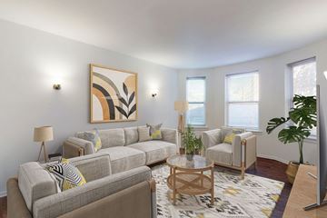 Chicago apartment for rent - A living room with a grey couch, a coffee table, and a painting on the wall.