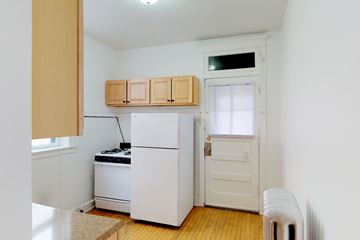 Chicago apartment for rent - A small kitchen with a white refrigerator and a white door.