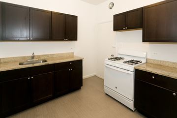 Chicago apartment for rent - A kitchen with brown cabinets and a white stove.