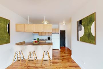 Chicago apartment for rent - A kitchen with wooden floors and a white table.