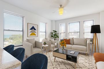 Chicago apartment for rent - A living room with a grey couch, a coffee table, and a painting on the wall.