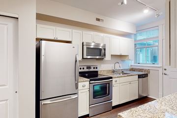 St. Louis apartment for rent - A kitchen with white appliances and cabinets.
