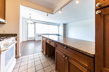 St. Louis apartment for rent - A kitchen with wooden cabinets and a tiled floor.