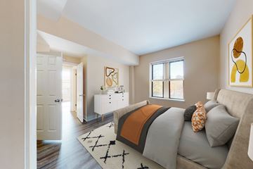 St. Louis apartment for rent - A living room with a grey couch and a white cabinet.