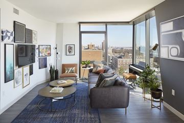 St. Louis apartment for rent - A living room with a couch, chair, and a table with a plant on it.