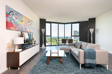 Chicago apartment for rent - A living room with a couch, a coffee table, and a large painting on the wall.