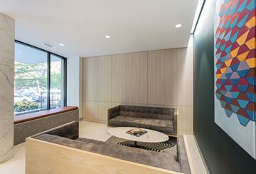 Kansas City apartment for rent - A modern living room with a grey couch and a large abstract painting on the wall.