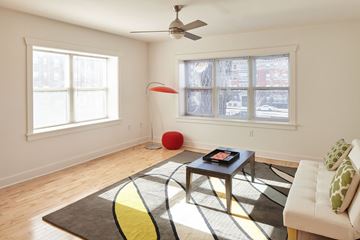 Kansas City apartment for rent - A living room with a white couch, a coffee table, and a rug with a yellow stripe.